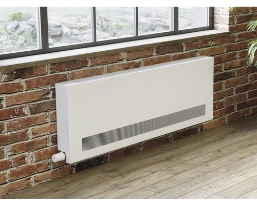 Radiateur blanc sous une fenêtre sur un mur de briques