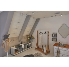 Helles Ankleidezimmer mit Kleiderständer, Kommode und flexibler Schienenbeleuchtung