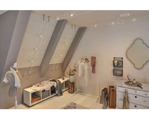 Einrichtung eines Dachgeschosszimmers mit Schienensystem zur Deckenbeleuchtung, Bank und Kommode