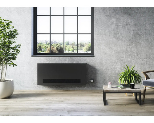 Wohnzimmer mit modernem Heizkörper an der Wand unter dem Fenster, Zimmerpflanze, Couchtisch und Sessel