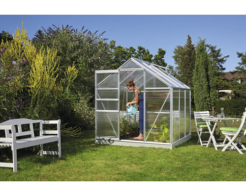 Serre de jardin avec femme arrosant des plantes