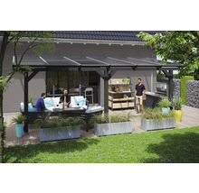 Terrasse mit Überdachung, Sitzgruppe, Grill und Pflanzenkübeln auf Rasenfläche