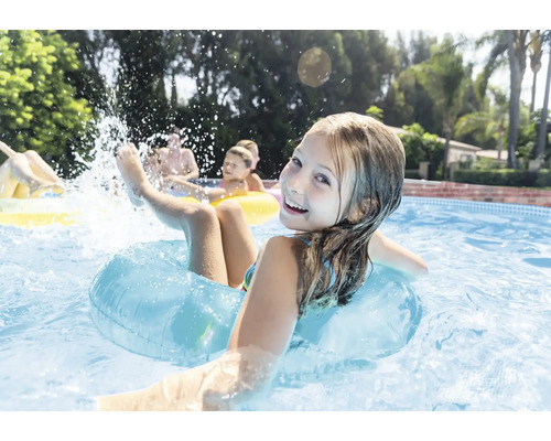 Mädchen mit Schwimmreifen im Pool mit anderen Personen