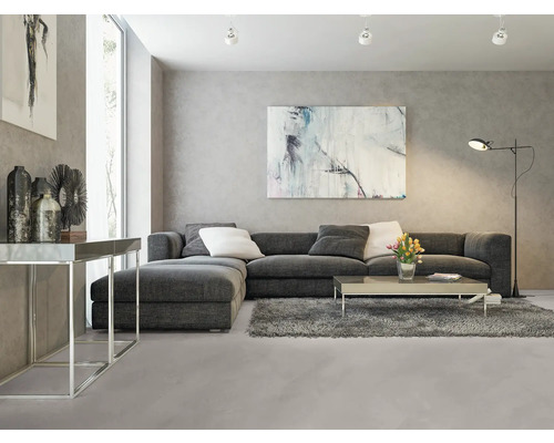 Wohnzimmer mit grauer Eckcouch, Couchtisch, Stehlampe und Kunstwerken an der Wand.