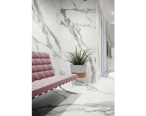 Innenraum mit rosa Sofa, Pflanze und Fliesen in Marmoroptik an Wand und Boden