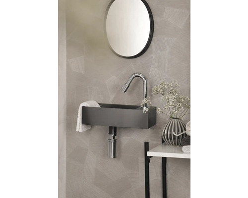 Modernes Badezimmer mit Waschbecken, Armatur und rundem Spiegel