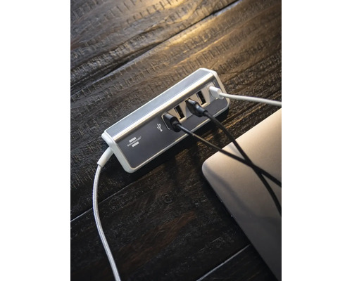 USB Hub mit mehreren angeschlossenen Kabeln auf einem Schreibtisch
