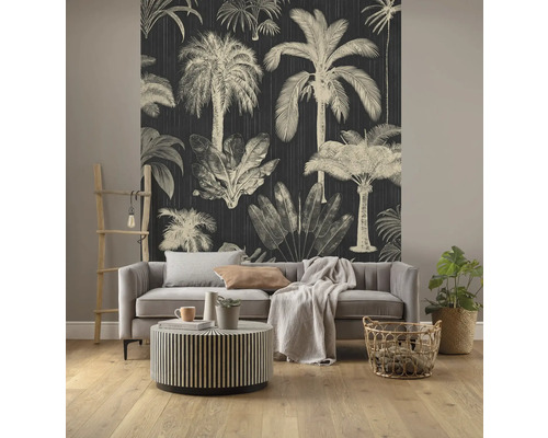 Wohnzimmer mit dunkler Tapete mit Palmenmotiven, Sofa und rundem Tisch
