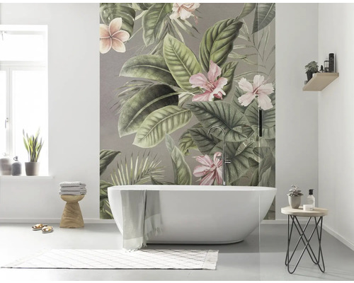 Badezimmer mit Badewanne und Fototapete mit tropischen Pflanzenmotiven.