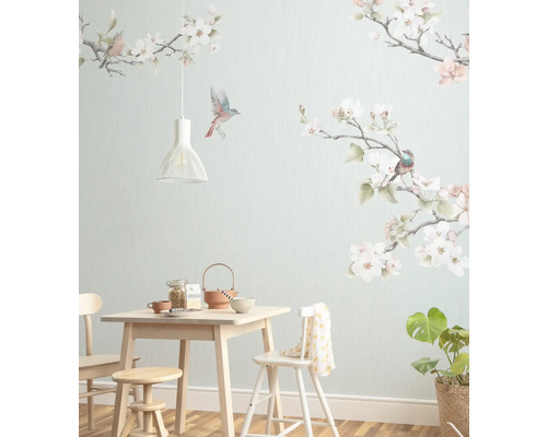 Papier peint panoramique intissé P264-VD3 Apple Blossom 3 pces 300 x 250 cm Pièce lumineuse avec table à manger, chaises, suspension, plante d''intérieur et décoration murale avec fleurs et oiseaux.
