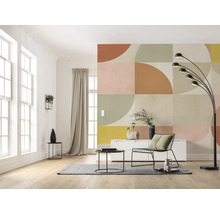 Salon avec décoration murale géométrique, lampadaire, tapis, table et chaise