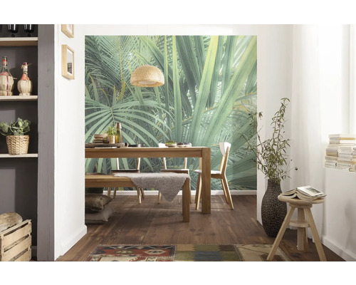 Salle à manger avec table en bois, chaises et fresque murale avec motif de jungle