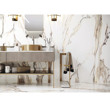 Salle de bains avec meuble-lavabo, miroir et porte-serviettes devant un mur carrelé en marbre