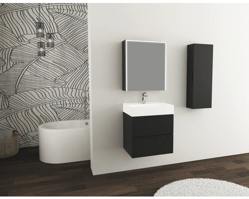 Salle de bains moderne avec lavabo, miroir, armoire suspendue et baignoire devant un mur à motif de feuilles