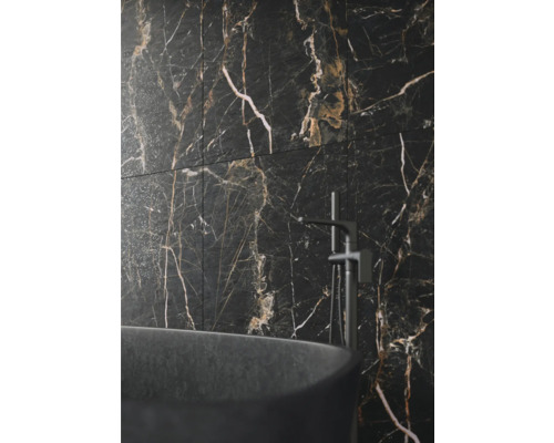 Badezimmer mit dunklen Marmorfliesen und Badewanne