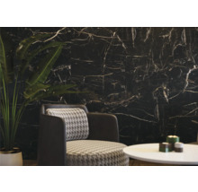 Intérieur avec mur en marbre noir, fauteuil et table