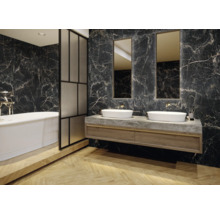 Salle de bains avec baignoire, meuble-lavabo, lavabos et miroirs devant un carrelage mural imitation marbre