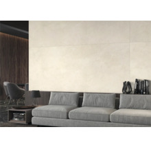 Espace de vie lumineux avec de grands carreaux muraux, un canapé gris et des détails en bois foncé