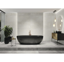 Salle de bains moderne avec baignoire îlot, lavabo et carrelage grand format.