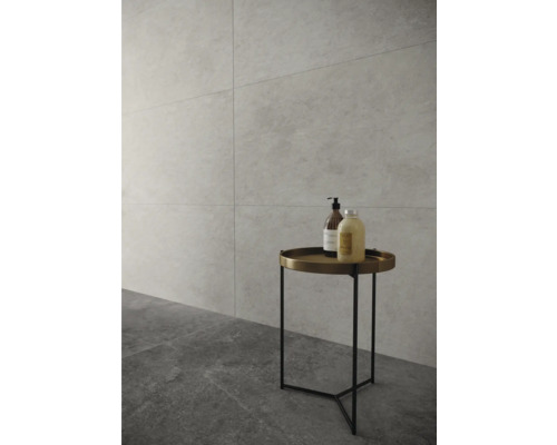 Badezimmer mit Fliesenboden und Wandfliesen, sowie einem runden Beistelltisch