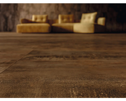 Nahaufnahme von dunkelbraunem Bodenbelag mit Couch im Hintergrund