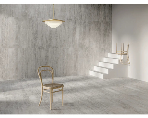 Innenraum mit grau gemusterten Fliesen, einer Deckenleuchte, einem Stuhl und einer Treppe