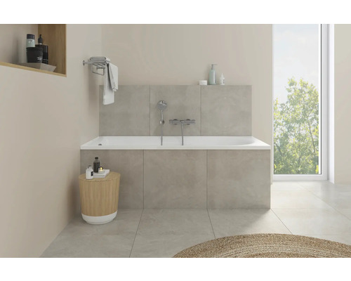 Helles Badezimmer mit Badewanne, Armatur und Ablagefläche