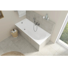 Vue claire de salle de bains avec baignoire blanche, robinetterie et espace de rangement