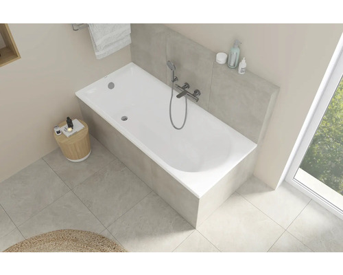 Helle Badezimmeransicht mit weißer Badewanne, Armatur und Ablagefläche
