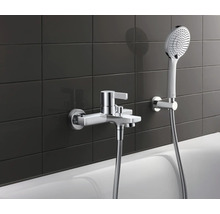 Robinet de baignoire apparent avec douchette à main devant un fond de carreaux sombres