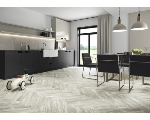 Helle Küche mit modernen Küchenschränken, Esstisch mit Stühlen und Holzfußboden in Fischgrätmuster.