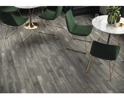 Intérieur avec carrelage de sol gris aspect bois, tables et chaises