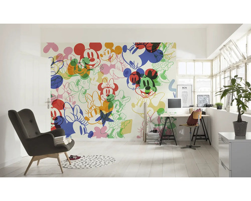Pièce lumineuse avec un papier peint mural à motifs Mickey Mouse, un bureau et un fauteuil.