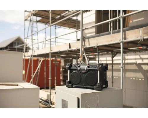 Radio de chantier devant un bâtiment inachevé avec échafaudage