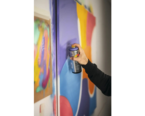 Une personne utilise de la peinture aérosol sur une toile pour des projets artistiques.