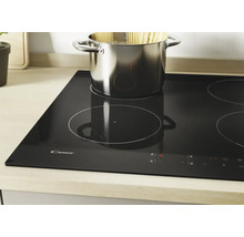 Plaque à induction Candy noire avec quatre zones de cuisson et une casserole