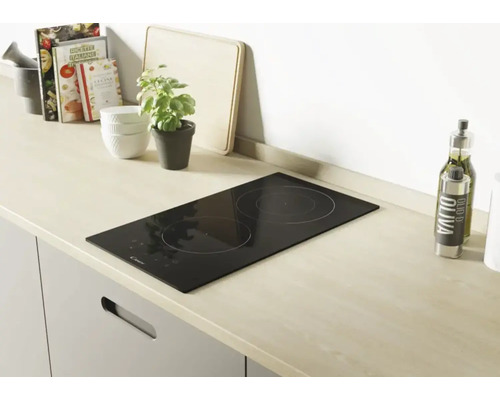 Schwarzes Kochfeld mit zwei Kochzonen in einer modernen Küche.