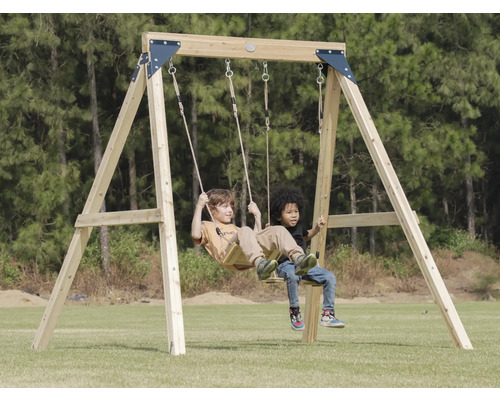 Zwei Kinder schwingen auf einer Holzschaukel im Garten.