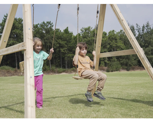 Kinder spielen auf einer Holzschaukel im Freien.