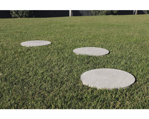 Drei runde Trittplatten aus Stein im Gras