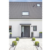Maison individuelle avec tuiles grises, porte d''entrée et entrée pavée.
