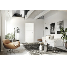Espace de vie lumineux avec porte, fauteuil, canapé et éléments décoratifs.