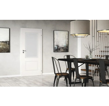 Salle à manger lumineuse avec table, chaises, suspensions et porte intérieure avec insert en verre.