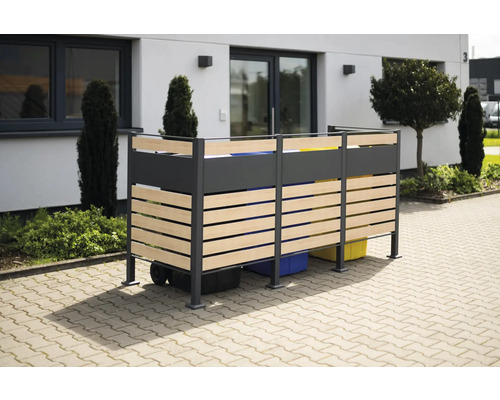 Mülltonnenbox aus Metall und Holzlatten vor einem Wohnhaus