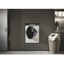 Machine à laver intégrée dans les meubles de salle de bain à côté du panier à linge