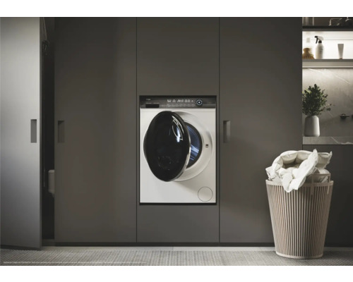 Machine à laver intégrée dans les meubles de salle de bain à côté du panier à linge