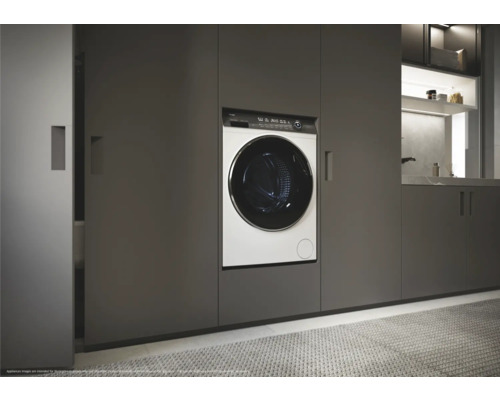 Waschmaschine eingebaut in einem modernen Badezimmer mit grauen Schränken.