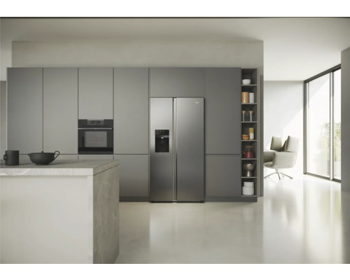 Cuisine lumineuse avec armoires encastrées, four et réfrigérateur côte à côte