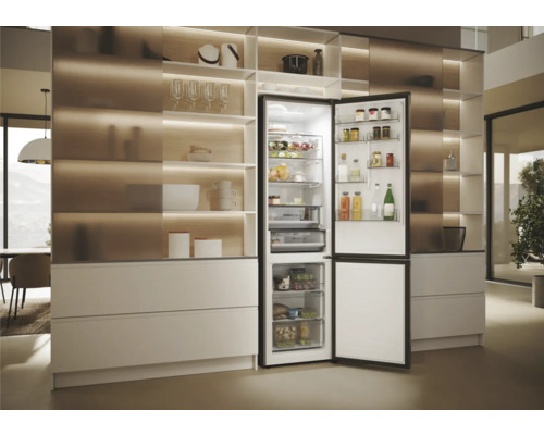 Offener Kühlschrank in einer hellen Küche mit Regalen und Schubladen zur Aufbewahrung von Lebensmitteln.