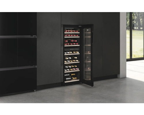 Offener Weinkühlschrank mit mehreren Weinflaschen in einem modernen Interieur.